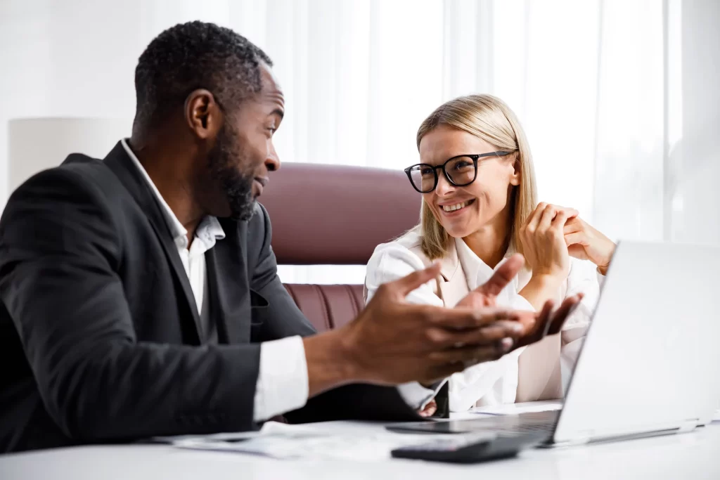 Two people in a one-on-one meeting discussing student loan options on a laptop.