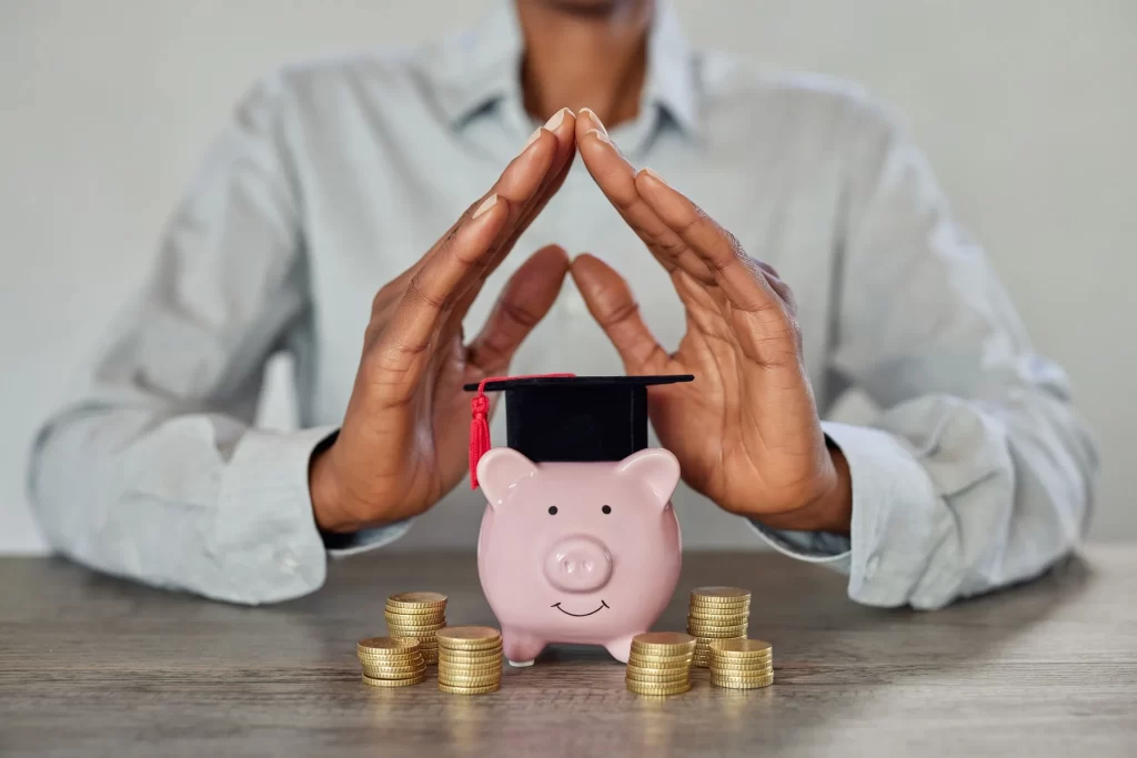 Piggy bank with coins and a graduation cap, symbolizing saving and planning for college expenses.
