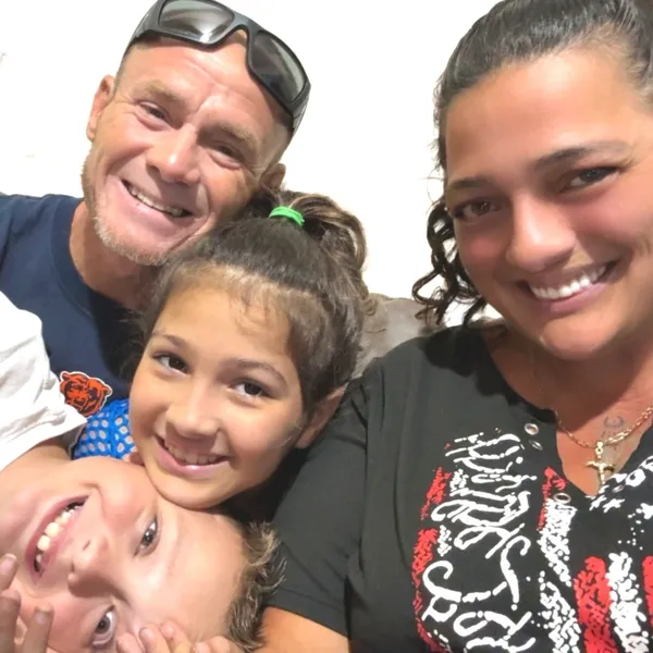 Danielle and family members gathered closely together in a group photo.