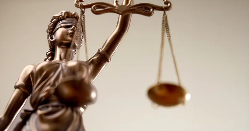 Statue of Lady Justice holding scales, symbolizing law, fairness, and legal compliance.